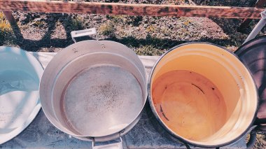 Birkaç boş tava. Büyük kaplar dolusu su. bir sürü renkli tencere.