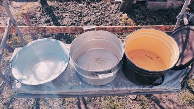 Birkaç boş tava. Büyük kaplar dolusu su. bir sürü renkli tencere.