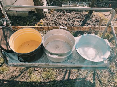 Birkaç boş tava. Büyük kaplar dolusu su. bir sürü renkli tencere.