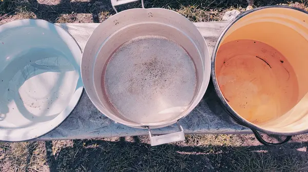 Birkaç boş tava. Büyük kaplar dolusu su. bir sürü renkli tencere.