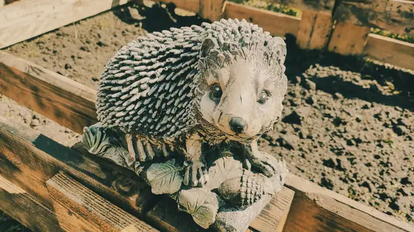 Kirpinin bahçe heykelciği. Kehribar kirpisi bir sehpanın üzerinde. Oyuncak kirpi. Bahçe dekoru. Sokak dekoru. retro biçimi.