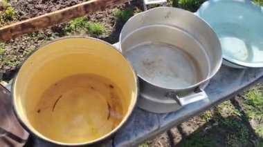 Birkaç boş tava. Büyük kaplar dolusu su. bir sürü renkli tencere.