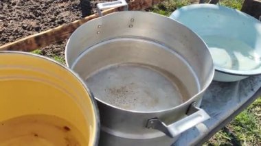 Birkaç boş tava. Büyük kaplar dolusu su. bir sürü renkli tencere.