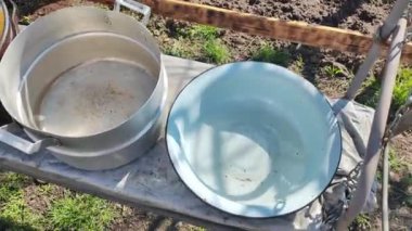 Birkaç boş tava. Büyük kaplar dolusu su. bir sürü renkli tencere.