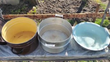 Birkaç boş tava. Büyük kaplar dolusu su. bir sürü renkli tencere.