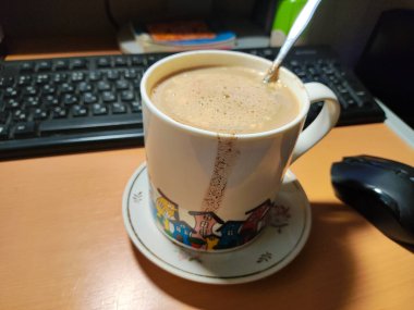 Büyük bir bardak ev yapımı kapuçino. Büyük bardakta sütlü kahve. Damlalı bir fincan kahve.