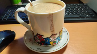 Büyük bir bardak ev yapımı kapuçino. Büyük bardakta sütlü kahve. Damlalı bir fincan kahve.