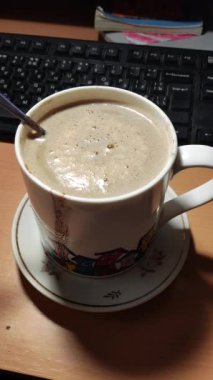 Büyük bir bardak ev yapımı kapuçino. Büyük bardakta sütlü kahve. Damlalı bir fincan kahve.