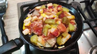 Alışılmadık ev yapımı çırpılmış yumurta. Çırpılmış yumurta, ekmek ve salatalık. Yağda ve yumurta. Kızartma tavasında domuz yağı. Ev yapımı yemek pişirmek. Kızarmış yumurta, doğranmış domates, soğan ve kırmızı biber..