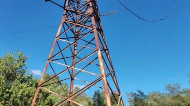 Güç iletim direkleri. Elektrik Kutbu, Yüksek Voltaj Hatları, Aktarım Kulesi, Elektrik Şebekesi, Voltaj ve Zaman Hızı Güzel Mavi Gökyüzü ve Bulutlar. Güç kabloları ve güç pilleri arasında uçuş..