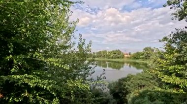 Sonbaharda yol boyunca yürüyorum. Sonbahar manzarası. Sonbahar yaprakları yerde. Dar yol. Nehir kenarında yürüyüş. Göl ve gökyüzü. Güzel doğal manzara. HDR video 4K 60 fps.