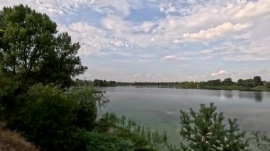 Sonbaharda yol boyunca yürüyorum. Sonbahar manzarası. Sonbahar yaprakları yerde. Dar yol. Nehir kenarında yürüyüş. Göl ve gökyüzü. Güzel doğal manzara. HDR video 4K 60 fps.