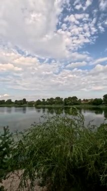 Sonbaharda yol boyunca yürüyorum. Sonbahar manzarası. Sonbahar yaprakları yerde. Dar yol. Nehir kenarında yürüyüş. Göl ve gökyüzü. Güzel doğal manzara. HDR video 4K 60 fps.