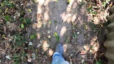 Bir adam kötü bir yolda yürüyor. Bacakları bir patikada yürüyor. Bacakları dolambaçlı bir yolda yürüyor. Bir adam yürüyor.