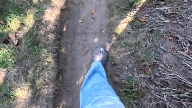 Bir adam kötü bir yolda yürüyor. Bacakları bir patikada yürüyor. Bacakları dolambaçlı bir yolda yürüyor. Bir adam yürüyor.