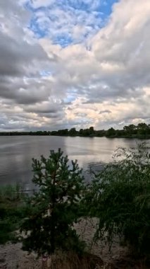 Bulutlu güzel doğal manzara. Suyun üzerindeki bulutlar. Sudaki yansıma. Göl kıyısında. Nehirli manzara. Nehir ve bulutlar. Fırtınadan önce hava. Kasırga. hdr video.