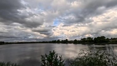 Bulutlu güzel doğal manzara. Suyun üzerindeki bulutlar. Sudaki yansıma. Göl kıyısında. Nehirli manzara. Nehir ve bulutlar. Fırtınadan önce hava. Kasırga. hdr video.