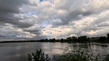 Bulutlu güzel doğal manzara. Suyun üzerindeki bulutlar. Sudaki yansıma. Göl kıyısında. Nehirli manzara. Nehir ve bulutlar. Fırtınadan önce hava. Kasırga. hdr video.