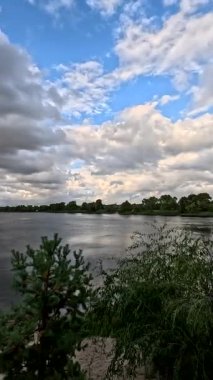 Bulutlu güzel doğal manzara. Suyun üzerindeki bulutlar. Sudaki yansıma. Göl kıyısında. Nehirli manzara. Nehir ve bulutlar. Fırtınadan önce hava. Kasırga. hdr video.