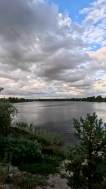 Bulutlu güzel doğal manzara. Suyun üzerindeki bulutlar. Sudaki yansıma. Göl kıyısında. Nehirli manzara. Nehir ve bulutlar. Fırtınadan önce hava. Kasırga. hdr video.