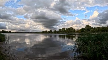 Bulutlu güzel doğal manzara. Suyun üzerindeki bulutlar. Sudaki yansıma. Göl kıyısında. Nehirli manzara. Nehir ve bulutlar. Fırtınadan önce hava. Kasırga. hdr video.