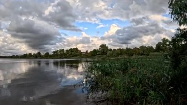 Bulutlu güzel doğal manzara. Suyun üzerindeki bulutlar. Sudaki yansıma. Göl kıyısında. Nehirli manzara. Nehir ve bulutlar. Fırtınadan önce hava. Kasırga. hdr video.