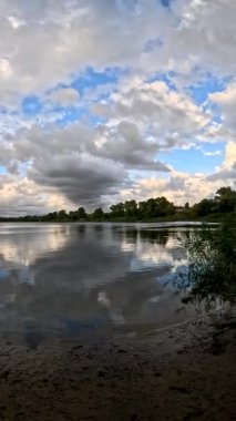 Bulutlu güzel doğal manzara. Suyun üzerindeki bulutlar. Sudaki yansıma. Göl kıyısında. Nehirli manzara. Nehir ve bulutlar. Fırtınadan önce hava. Kasırga. hdr video.