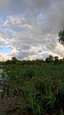 Bulutlu güzel doğal manzara. Suyun üzerindeki bulutlar. Sudaki yansıma. Göl kıyısında. Nehirli manzara. Nehir ve bulutlar. Fırtınadan önce hava. Kasırga. hdr video.