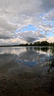 Bulutlu güzel doğal manzara. Suyun üzerindeki bulutlar. Sudaki yansıma. Göl kıyısında. Nehirli manzara. Nehir ve bulutlar. Fırtınadan önce hava. Kasırga. hdr video.
