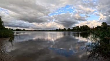 Bulutlu güzel doğal manzara. Suyun üzerindeki bulutlar. Sudaki yansıma. Göl kıyısında. Nehirli manzara. Nehir ve bulutlar. Fırtınadan önce hava. Kasırga. hdr video.