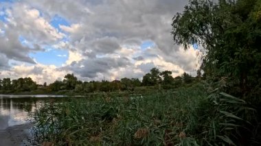 Bulutlu güzel doğal manzara. Suyun üzerindeki bulutlar. Sudaki yansıma. Göl kıyısında. Nehirli manzara. Nehir ve bulutlar. Fırtınadan önce hava. Kasırga. hdr video.