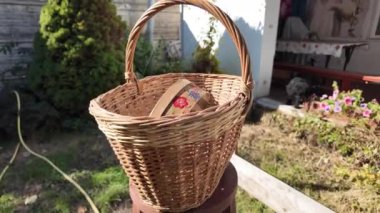 Hasır sepet. Ahşap masada, saplı, büyük el yapımı bir sepet var. Cilalanmış rattan yapılmış hasır sepetin dokusu, yakın plan.