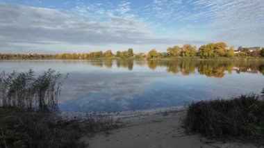 Suyla doğal manzara. Suda yansıması olan güzel bir manzara. Gökyüzü suya yansıyor. Gün batımında nehir. Şafakta göl. Su yüzeyi. Balık tutmak. Göldeki evler.