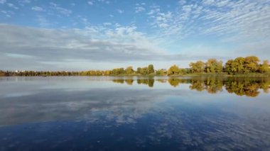Suyla doğal manzara. Suda yansıması olan güzel bir manzara. Gökyüzü suya yansıyor. Gün batımında nehir. Şafakta göl. Su yüzeyi. Balık tutmak. Göldeki evler.