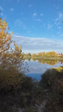 Suyla doğal manzara. Suda yansıması olan güzel bir manzara. Gökyüzü suya yansıyor. Gün batımında nehir. Şafakta göl. Su yüzeyi. Balık tutmak. Göldeki evler.