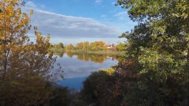 Suyla doğal manzara. Suda yansıması olan güzel bir manzara. Gökyüzü suya yansıyor. Gün batımında nehir. Şafakta göl. Su yüzeyi. Balık tutmak. Göldeki evler.