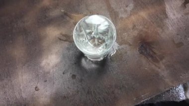 Su şeffaf bir cam yavaş çekim videosunda. Bir bardağa dökülen beyaz şarabın yaratıcı makro yavaş çekim videosu. Soda, yüzen su yüzeyini kapatır. Maden suyu dökülüyor şeffaf
