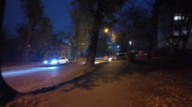 Gece şehrinin sokakları. Şehirde fener ışığı var. Karanlıkta yoldan geçenler. Taşra kasabası. Gece caddelerinde yürü.