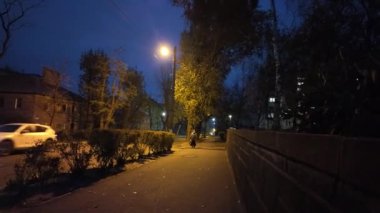 Gece şehrinin sokakları. Şehirde fener ışığı var. Karanlıkta yoldan geçenler. Taşra kasabası. Gece caddelerinde yürü.