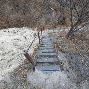 Eski demir merdivenler. Paslı metal merdivenler. Tehlikeli, sarp, eski merdivenler. Dağdan iniyoruz..