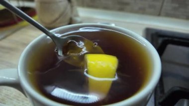 Limonlu siyah çay. Yavaş çekim videosu. Bardakta çay. Adam büyük bir fincanda çay hazırlıyor..