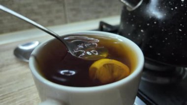 Limonlu siyah çay. Yavaş çekim videosu. Bardakta çay. Adam büyük bir fincanda çay hazırlıyor..