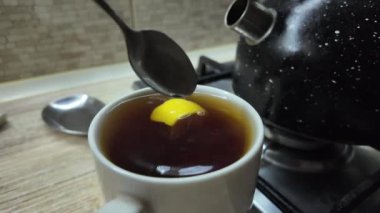 Limonlu siyah çay. Yavaş çekim videosu. Bardakta çay. Adam büyük bir fincanda çay hazırlıyor..