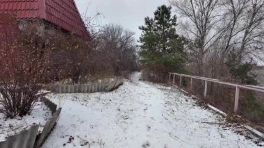 Kışın doğa yürüyüşü. Kar yağıyormuş. Yavaş çekim videosu. Karlı bir yol. Kışın yürü. Karda eski demir çitler.