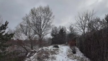 Kışın doğa yürüyüşü. Kar yağıyormuş. Yavaş çekim videosu. Karlı bir yol. Kışın yürü. Karda eski demir çitler.