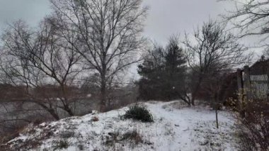 Kışın doğa yürüyüşü. Kar yağıyormuş. Yavaş çekim videosu. Karlı bir yol. Kışın yürü. Karda eski demir çitler.