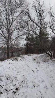 Kışın doğa yürüyüşü. Kar yağıyormuş. Yavaş çekim videosu. Karlı bir yol. Kışın yürü. Karda eski demir çitler.