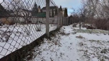 Kışın doğa yürüyüşü. Kar yağıyormuş. Yavaş çekim videosu. Karlı bir yol. Kışın yürü. Karda eski demir çitler.