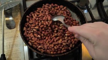 Kızarmış fıstık. Adam kızartma tavasında fıstık kızartıyor..