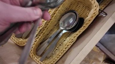 Mutfaktaki çekmecede kaşıklar ve çatallar. Çatal ve kaşıkla çatal bıçakla çekmeceyi açmak. Soldan hafif gün ışığıyla statik çekim. Döndürülebilir çekim.